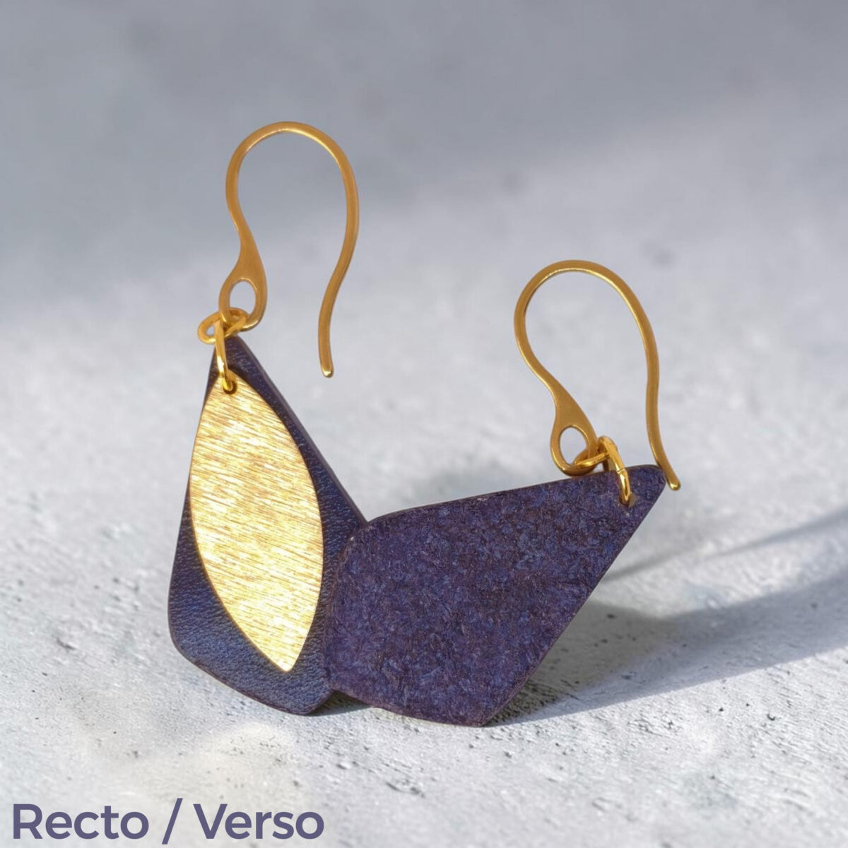 Boucles d'oreilles forme larme en cuir sauvage bleu, taille réduite, finition aniline et pendants dorés brossés, vues recto - verso se chevauchant, suspendues à des boucles dorées