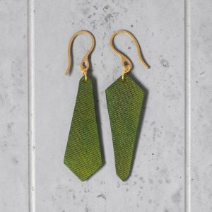 Boucles d'oreilles asymétriques formes cravates en cuir teinté vert forêt, finition lime vieillie, vues de face, suspendues à des boucles dorées, sur béton