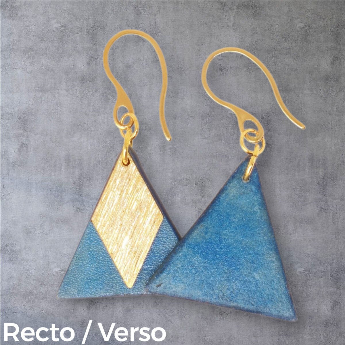 Boucles d'oreilles forme triangulaire en cuir teinture bleue, finition lisse et pendants losange dorés brossés vues recto - verso se chevauchant, suspendues à des boucles dorées