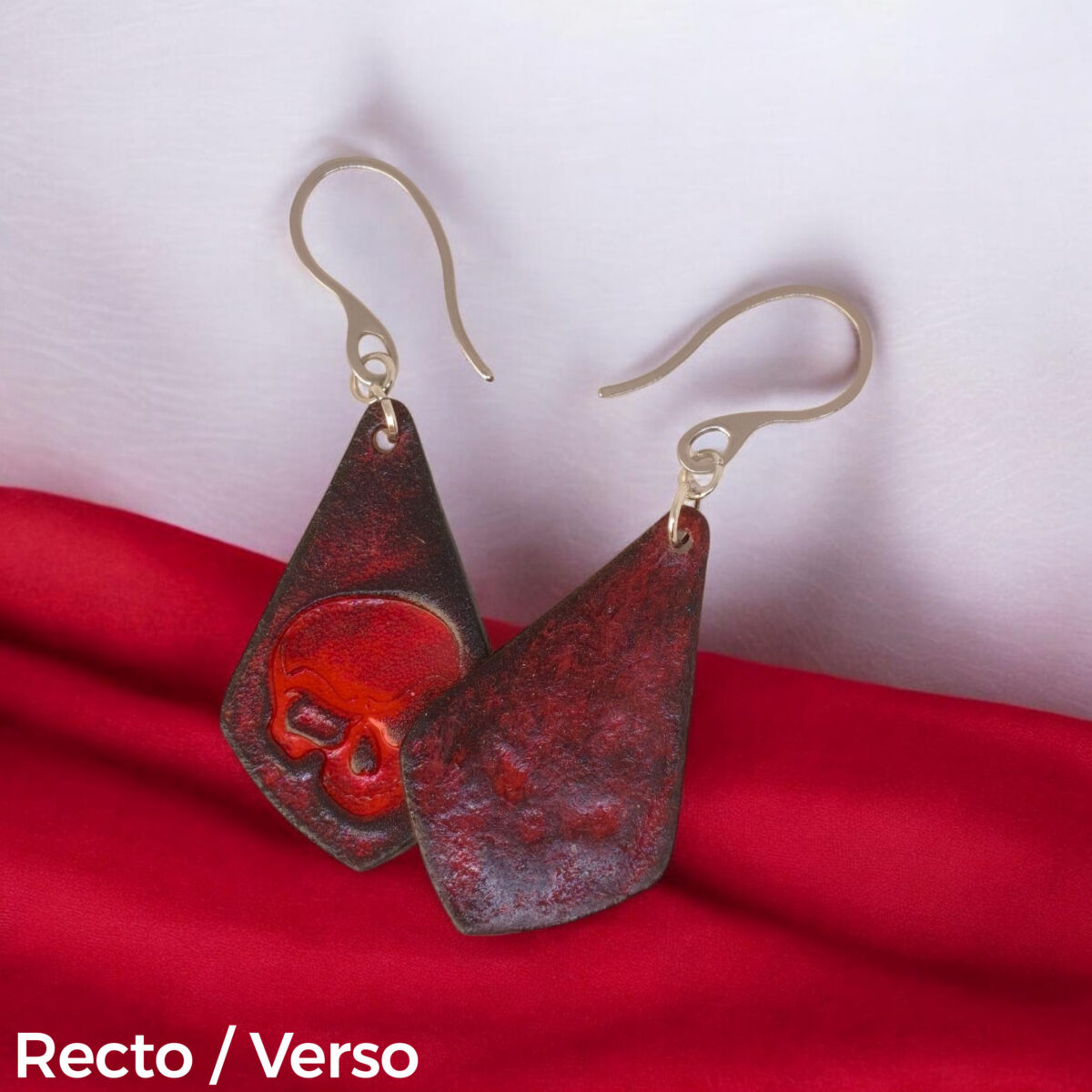 Boucles d'oreilles forme larme en cuir teinture rouge et noire, estampage tête de mort, vues recto - verso se chevauchant, suspendues à des boucles argentées