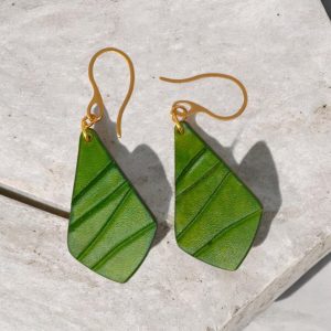 Boucles d'oreilles forme larme en cuir teinture vert forêt, finition galet, vues de face, suspendues à des boucles dorées sur pierre