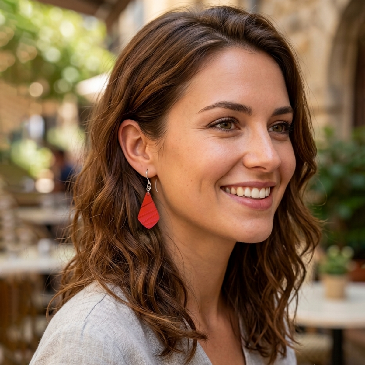 Boucles d'oreilles forme larme en cuir teinture rouge écarlate, finition galet, vues de face, suspendues à des boucles argentées sur un mannequin virtuel