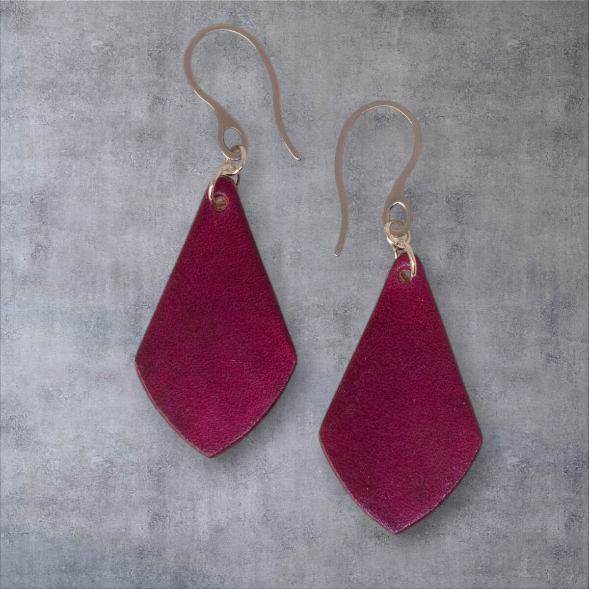 Boucles d'oreilles forme larme en cuir teinture violette, finition lisse, vues de face, suspendues à des boucles argentées sur fond gris