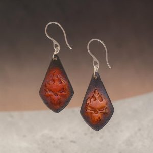 Boucles d'oreilles forme larme en cuir teinture noire, estampage tête de mort couleur cognac en dégradé, vues de face, suspendues à des boucles argentées, fond design