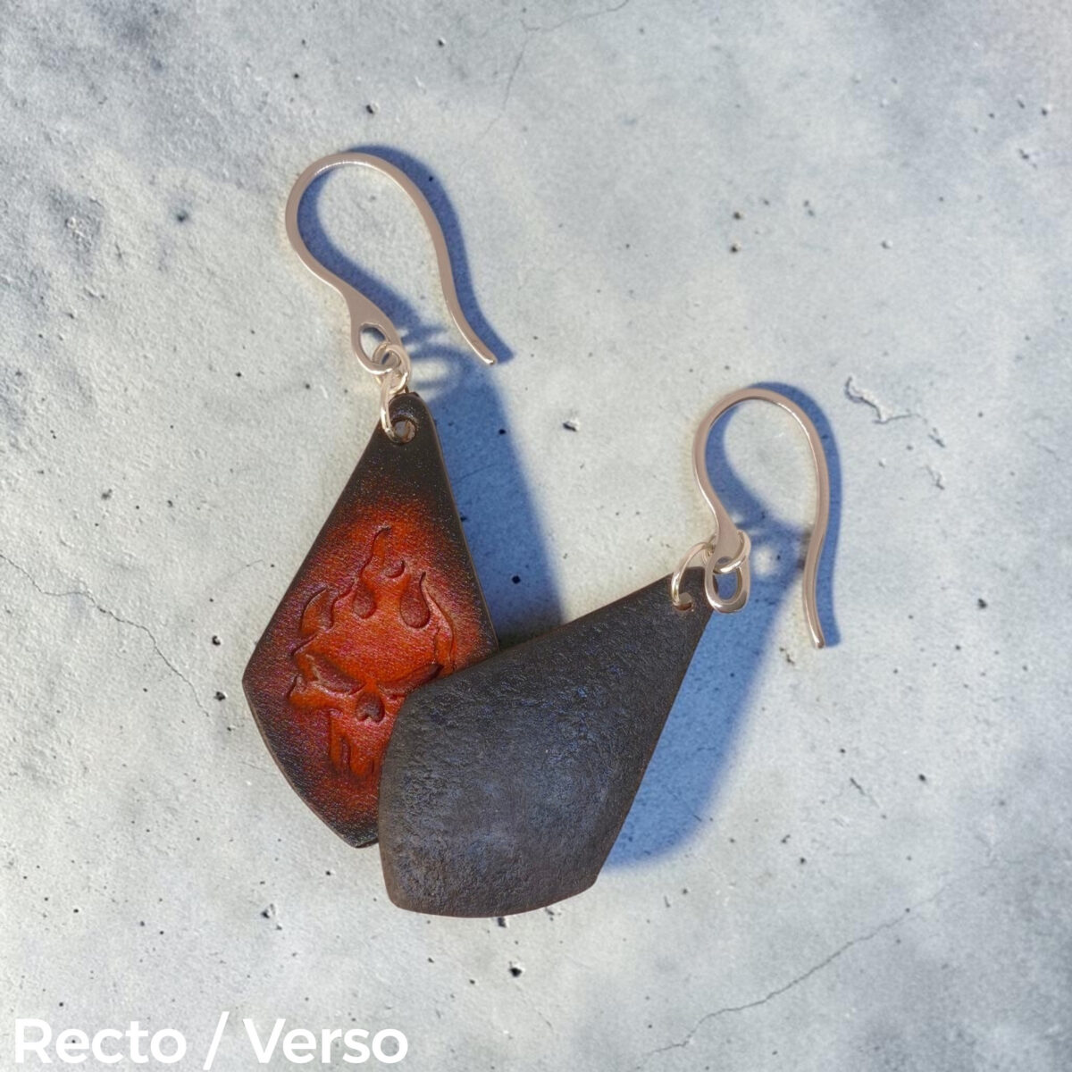 Boucles d'oreilles forme larme en cuir teinture noire, estampage tête de mort couleur cognac en dégradé, vues recto - verso se chevauchant, suspendues à des boucles argentées