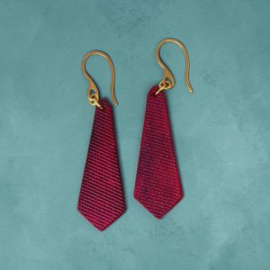 Boucles d'oreilles cravates en cuir teinté fuschia, finition lime vieillie, vues de face, suspendues à des boucles dorées, fond design