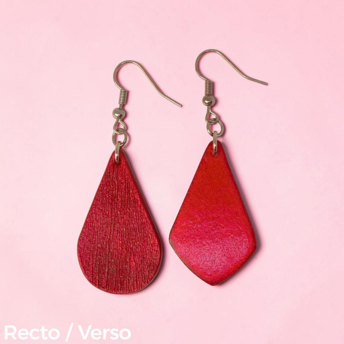 Boucle d'oreille forme larme en cuir teinture rouge, finition griffée, vue recto - verso, suspendue à une boucle argentée, fond design