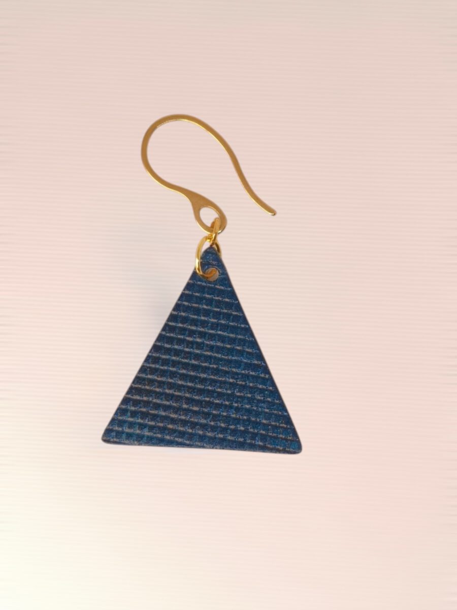 Boucle d'oreille forme triangulaire en cuir teinture bleue, texturage quadrillage, vue de face, suspendue à une boucle dorée, fond design