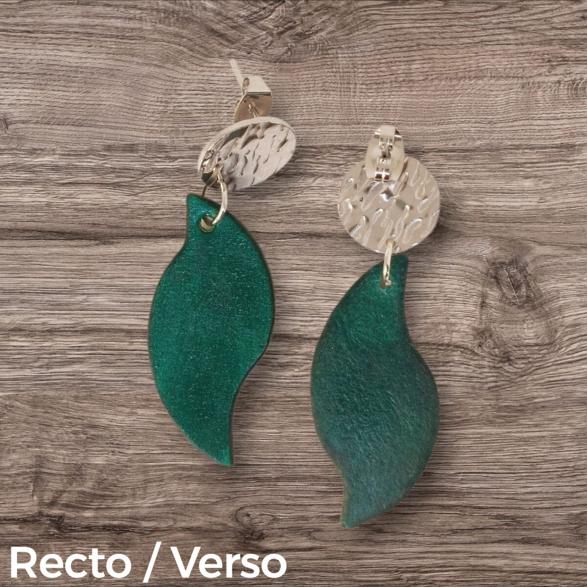 Boucles d'oreilles forme feuille asymétrique en cuir teinté vert d'eau, finition lisse, vues recto - verso, suspendues à des boucles argentées, fond bois