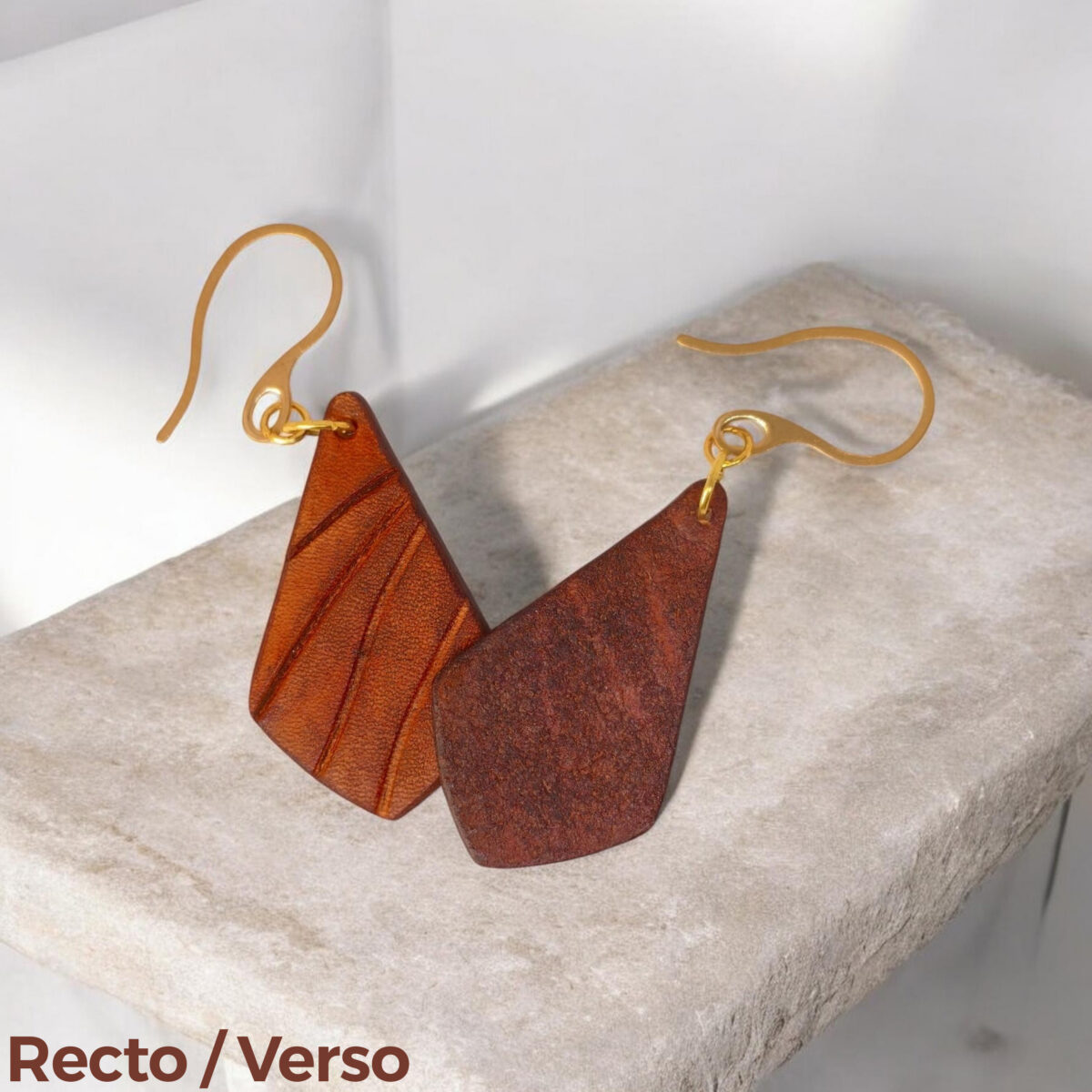 Boucles d'oreilles en cuir teinté cognac, vues recto - verso, suspendues à des crochets dorés