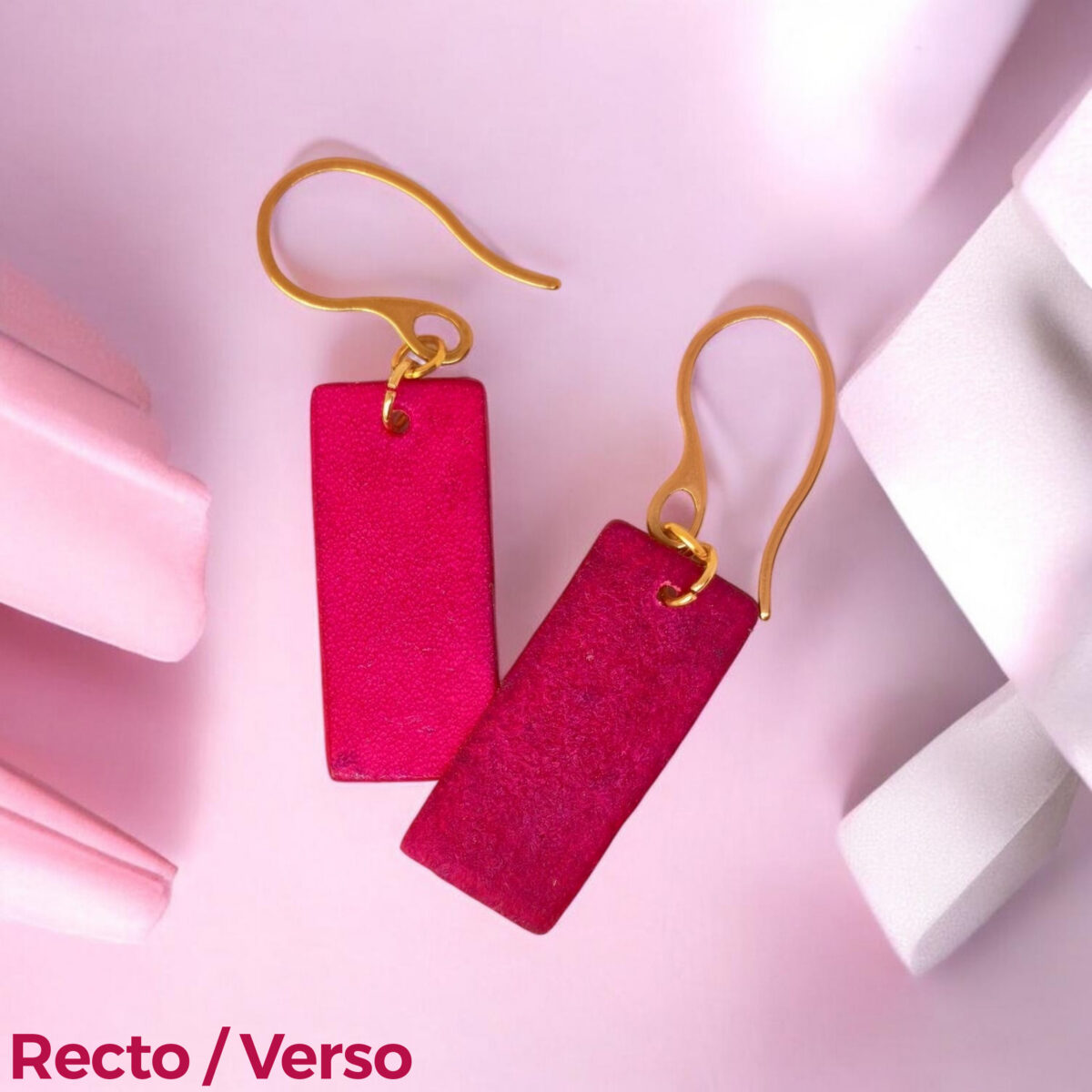 Boucles d'oreilles en cuir teintées en fuschia très girly et vives, vues recto - verso se chevauchant, suspendues à des crochets dorés