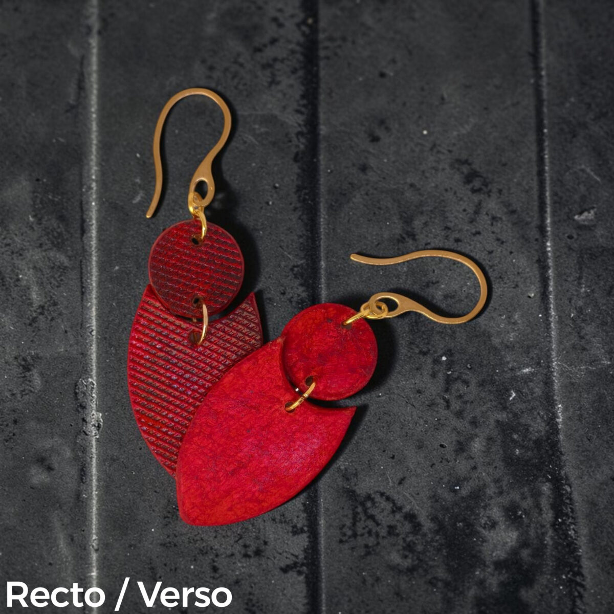 Boucles d'oreilles forme double rond + écu en cuir teinture rouge, texturage lime fine et finition vieillie, vues recto - verso se chevauchant, suspendues à des boucles dorées