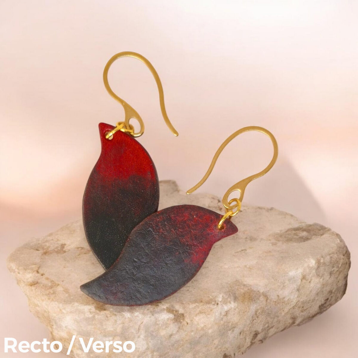 Boucles d'oreilles en cuir teintées en noir et rouge, vues recto - verso se chevauchant, suspendues à des crochets dorés