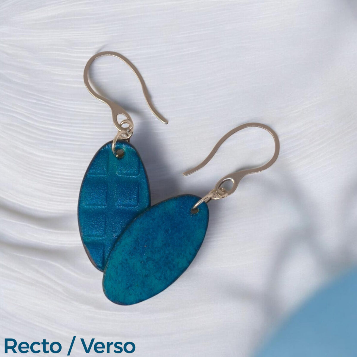 Boucles d'oreilles ovales en cuir teinte bleue, texturage carré, vues recto - verso, suspendues à des boucles argentées