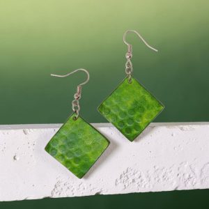 Boucles d'oreilles carrées en cuir teinté vert forêt, texturage ronds, vues de face, suspendues à des boucles gun-métal, sur pierre